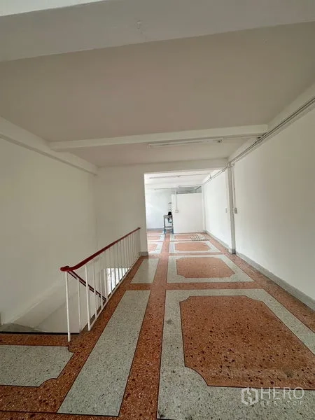 Shophouse for rent in Bangkok - Corner room with large windows, terrazzo floor and stair access.