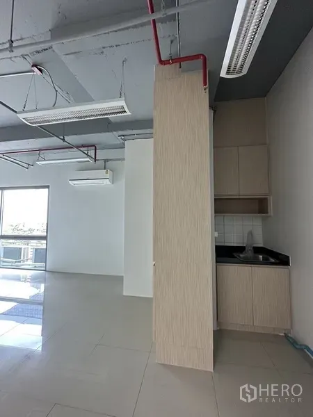 Office Space for rent in Khlong Toei, Bangkok - Compact pantry with sink and light wood cabinetry inside a bright office with sliding glass door.