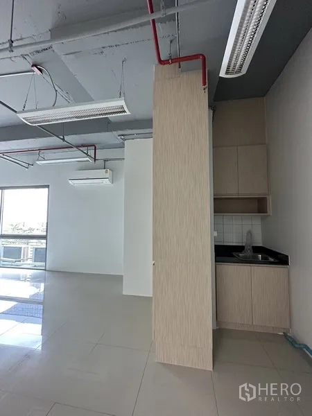 Office Space for rent in Khlong Toei, Bangkok - Compact pantry with sink and light wood cabinetry inside a bright office with sliding glass door.
