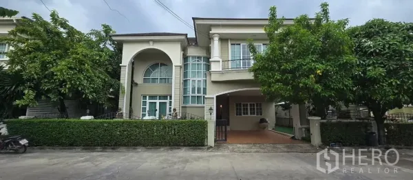 Detached House for rent in Mueang Pathum Thani, Pathum Thani - Front facade of the two-storey detached house featuring an arched porch and balcony.