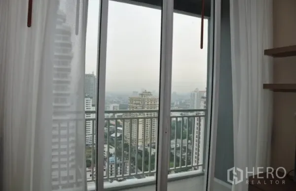 公寓 出租或出售在Watthana, Bangkok - 推拉门通往阳台，尽览城市景观。