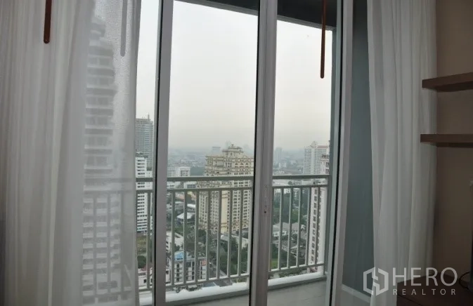 公寓 出租或出售在Watthana, Bangkok - 推拉门通往阳台，尽览城市景观。