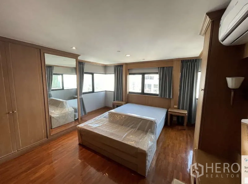 Condominium for rent - Large bedroom with wraparound windows, mirrored wardrobe and queen bed.