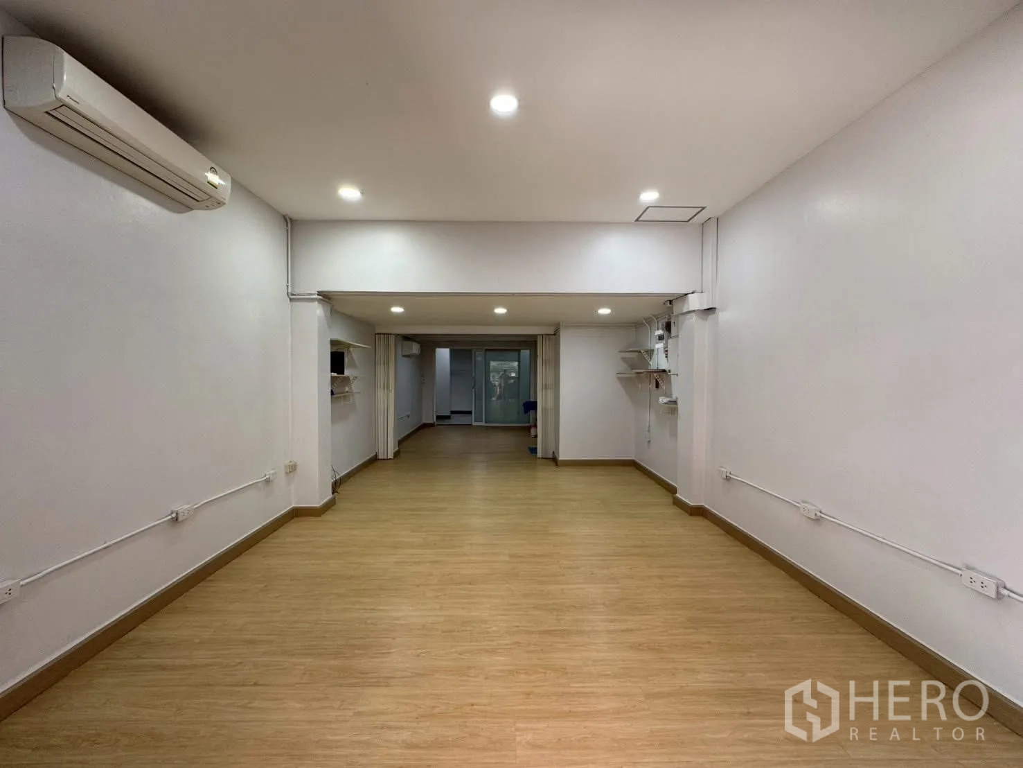 Home Office for rent in Sathon, Bangkok - Wide open hall with wood floors, recessed lighting, and white walls.