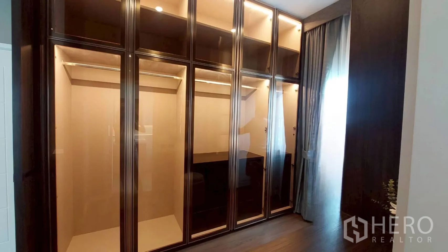Detached House for rent in Bang Phli, Samut Prakan - Bedroom wall of glass-front built-in wardrobes with interior lighting.