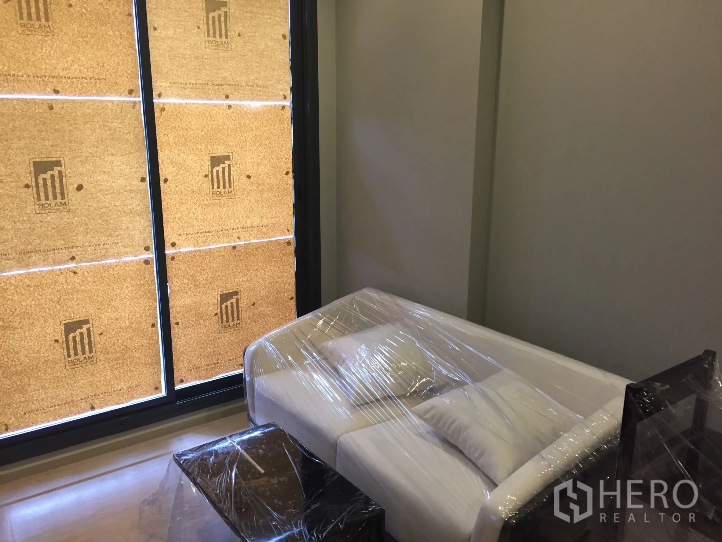 Condominium for rent in Watthana, Bangkok - Cozy living area with white sofa beside a full-height window.