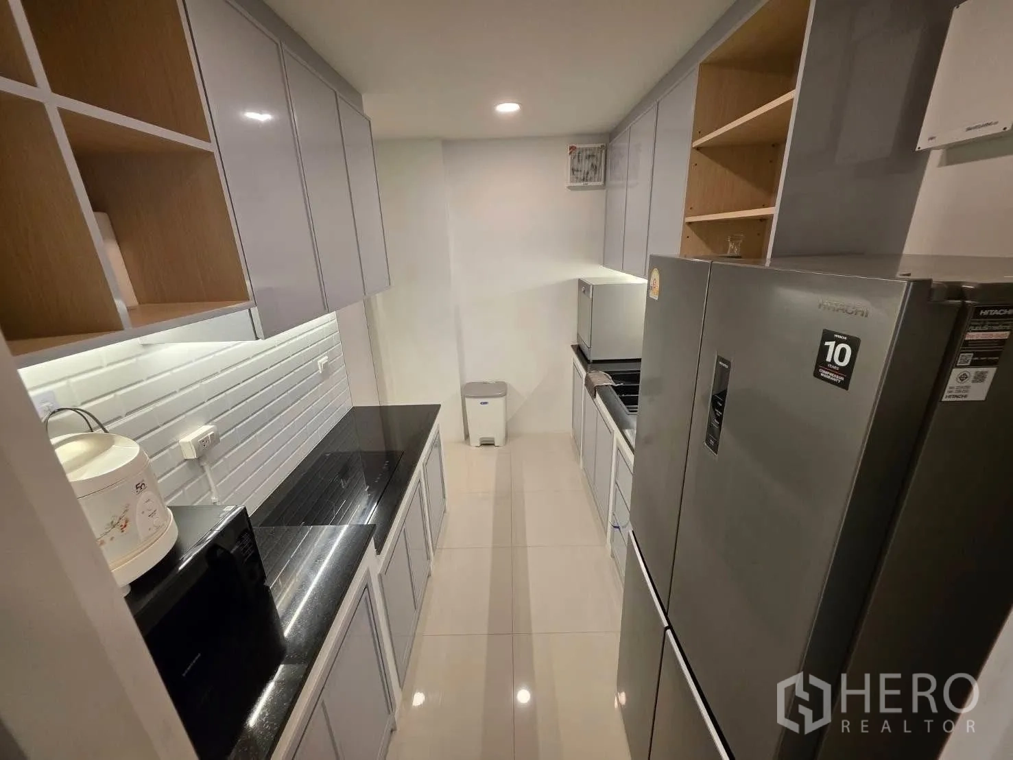 独栋房屋 for rent or sale in Bang Phli, Samut Prakan - 现代走廊式厨房，光面柜体、黑色台面与大冰箱。