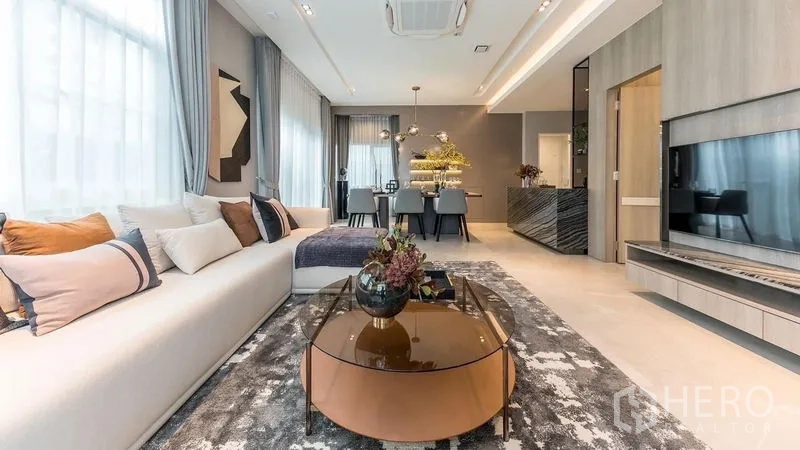 独立式住宅 出租在Prawet, Bangkok - 客厅设长沙发、圆形茶几与内置电视墙。