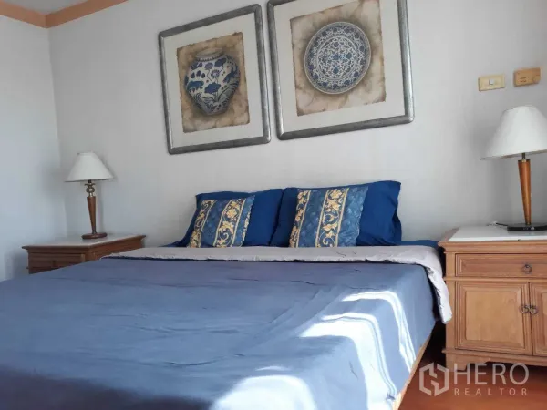 Condominium for rent or sale in Khlong Toei, Bangkok - Master bedroom with king bed, blue bedding, twin bedside tables and wall art.