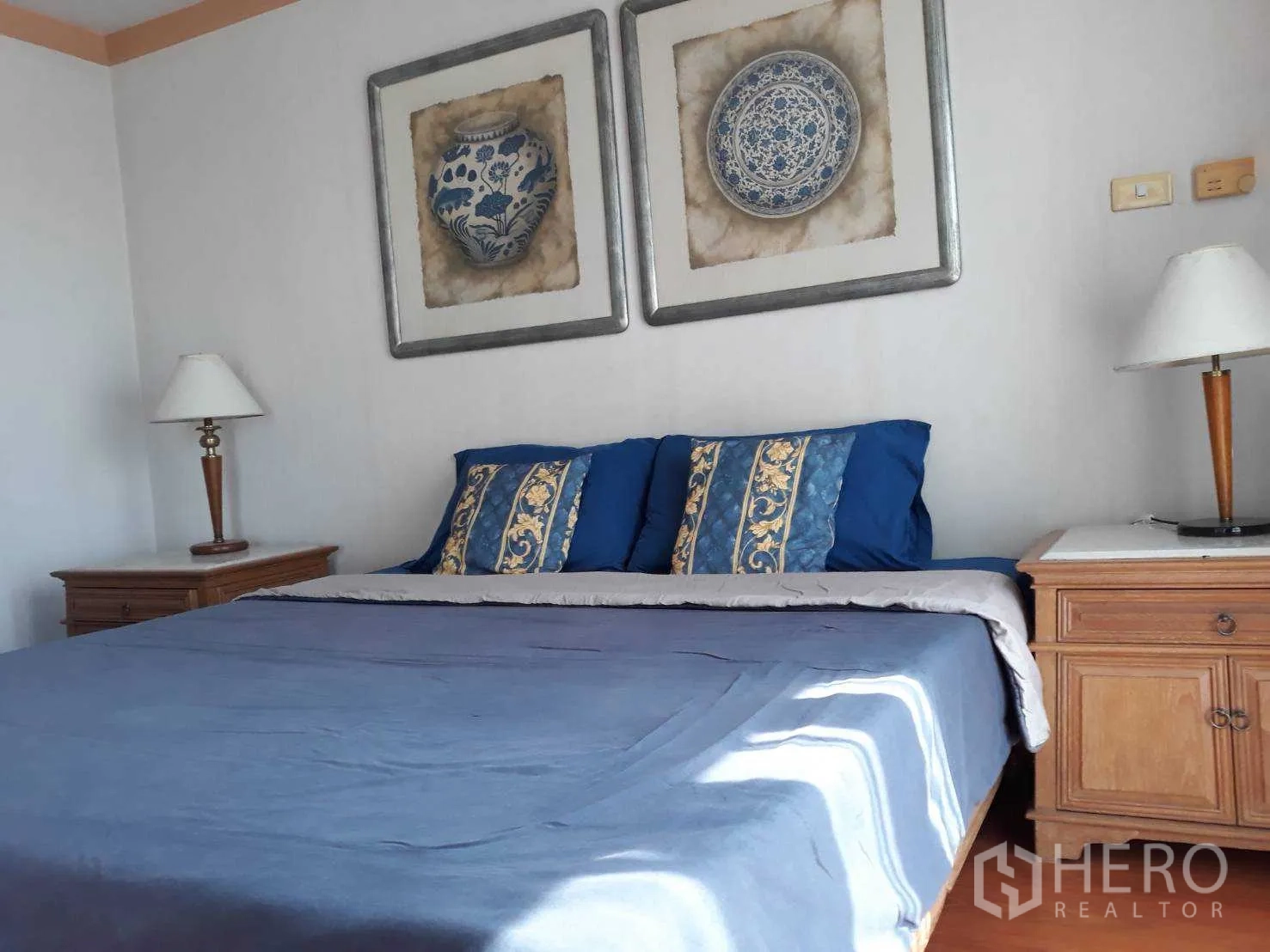 Condominium for rent or sale in Khlong Toei, Bangkok - Master bedroom with king bed, blue bedding, twin bedside tables and wall art.