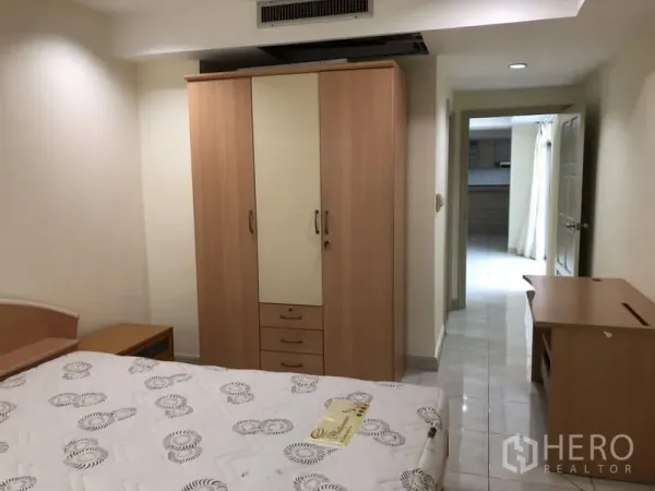Condominium for rent in Watthana, Bangkok - Secondary bedroom featuring a wardrobe, desk and view to the hallway.