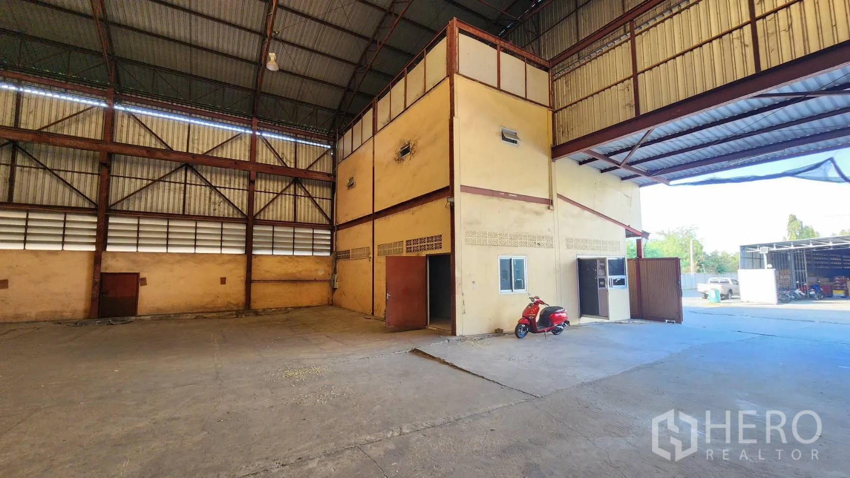 Warehouse for rent in Nonthaburi - Warehouse bay with attached two-storey office block and driveway.