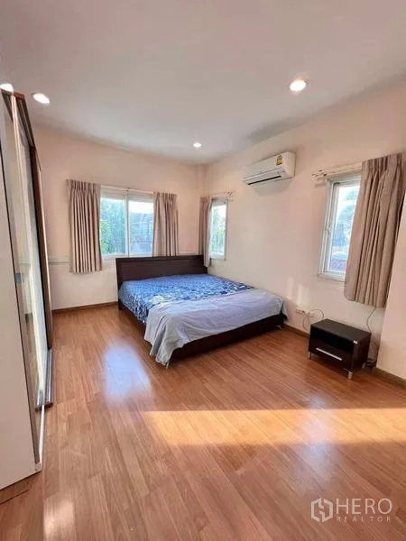 บ้าน ให้เช่าในLat Krabang, Bangkok - ห้องนอนหลักพื้นไม้ มีเตียงและเครื่องปรับอากาศ แสงธรรมชาติ