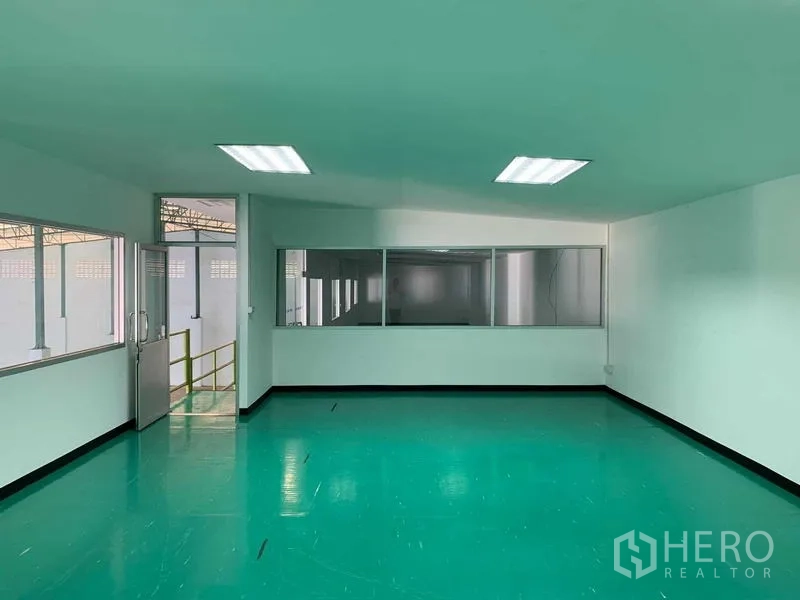 Warehouse for rent in Bang Phli, Samut Prakan - Bright corner office with green epoxy floor and internal windows facing the warehouse.