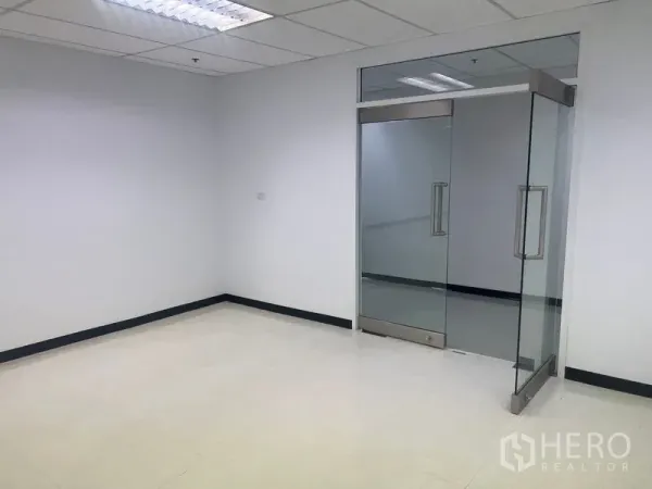 办公空间 出租在Watthana, Bangkok - 整洁角落空间，双扇玻璃门与浅色瓷砖地面。