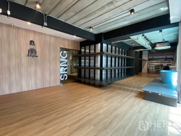带办公室的家 出租在Wang Thonglang, Bangkok - 一层展示厅，木地板、裸露混凝土顶与轨道灯及陈列架