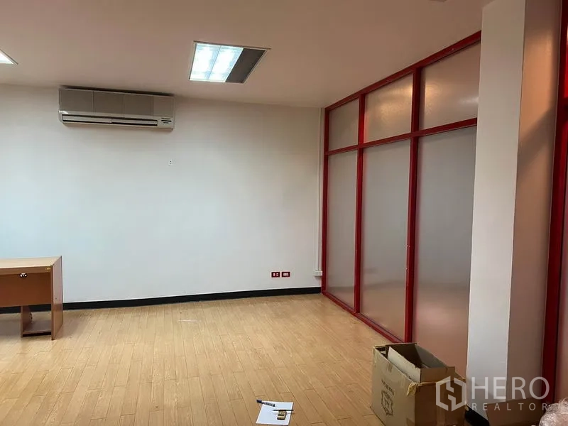 办公空间 出租在Khlong Toei, Bangkok - 独立办公区，红色框架磨砂玻璃隔断，壁挂空调，浅色木地板与书桌。