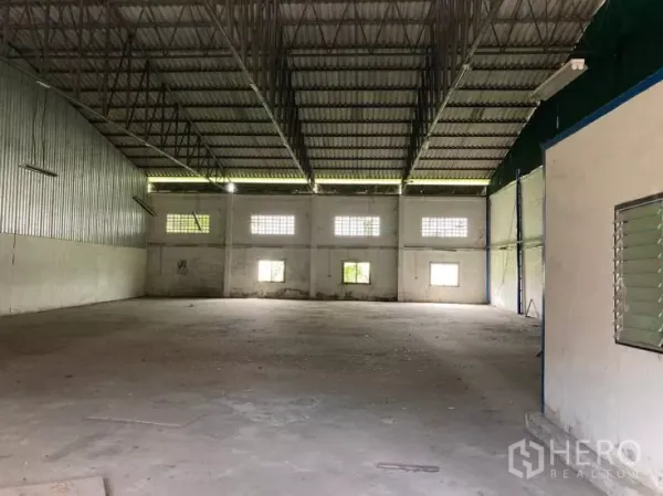 Factory for rent in Bang Phli, Samut Prakan - Spacious column-free factory interior with high steel truss roof, windows and concrete floor.