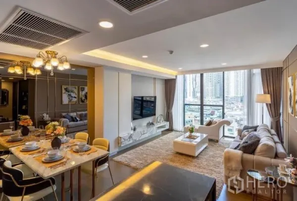 公寓 出租在Khlong Toei, Bangkok - 水晶吊灯上方的餐桌，眺望宽敞客厅与城市景观。