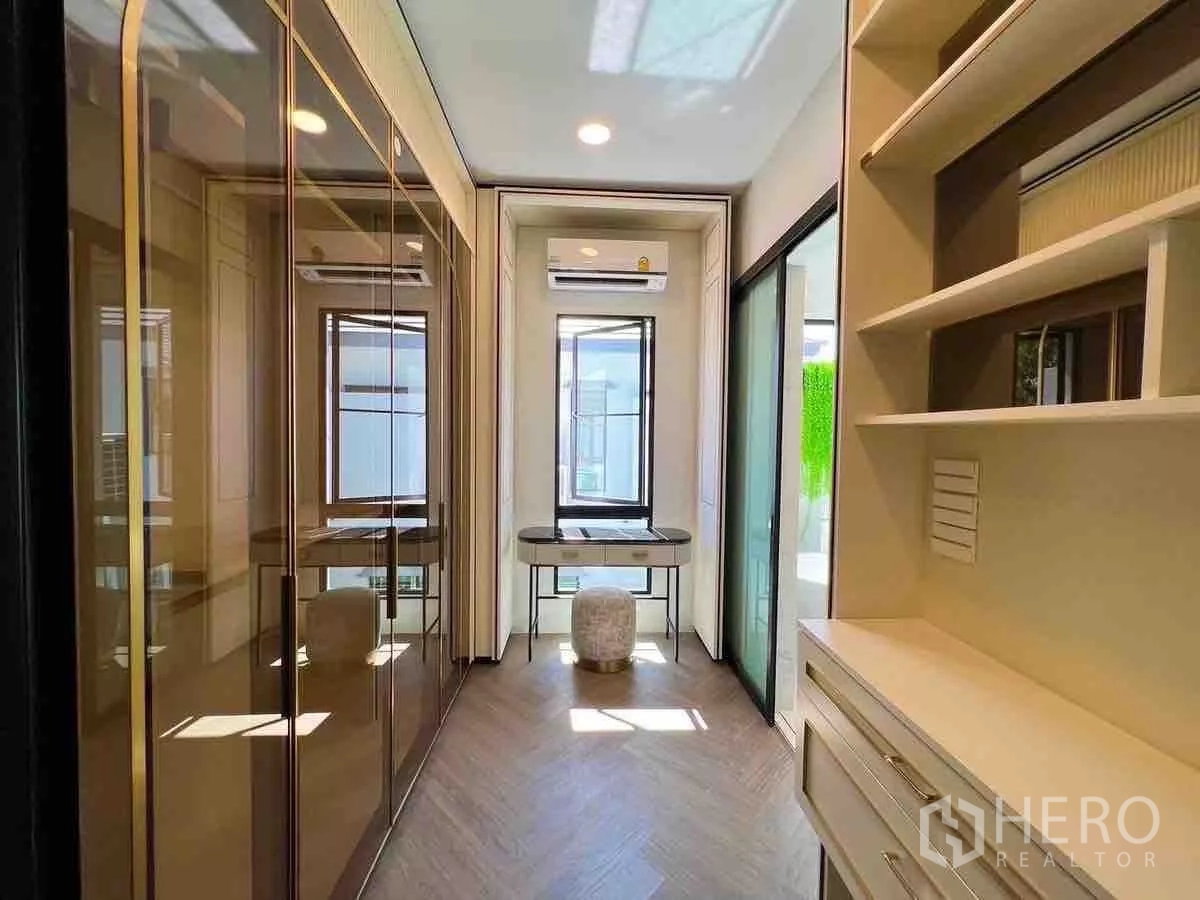 Detached House for rent or sale in Saphan Sung, Bangkok - Walk-in closet corridor with glass wardrobes and study desk
