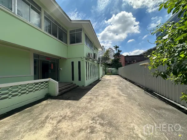 Retail Space for rent in Watthana, Bangkok - Side view of entrance and long driveway beside the building under sunny sky.