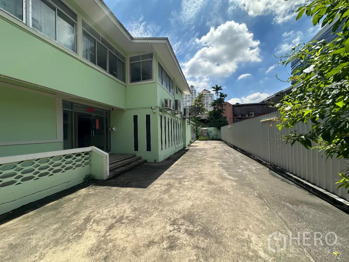 Retail Space for rent in Watthana, Bangkok - Side view of entrance and long driveway beside the building under sunny sky.