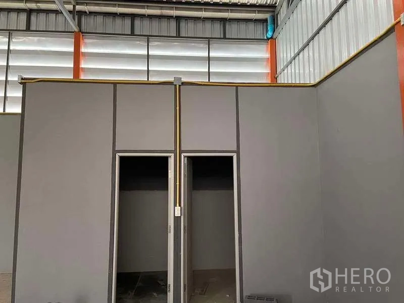 Warehouse for rent in Lam Luk Ka, Pathum Thani - Internal partition with two doorways for office or restroom use inside the warehouse.