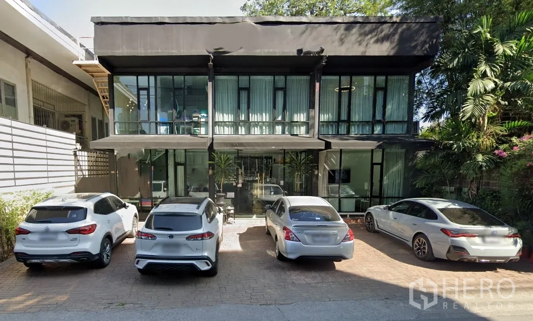 零售空间 for rent in Watthana, Bangkok - 两层落地玻璃立面建筑，门前可停多辆车。