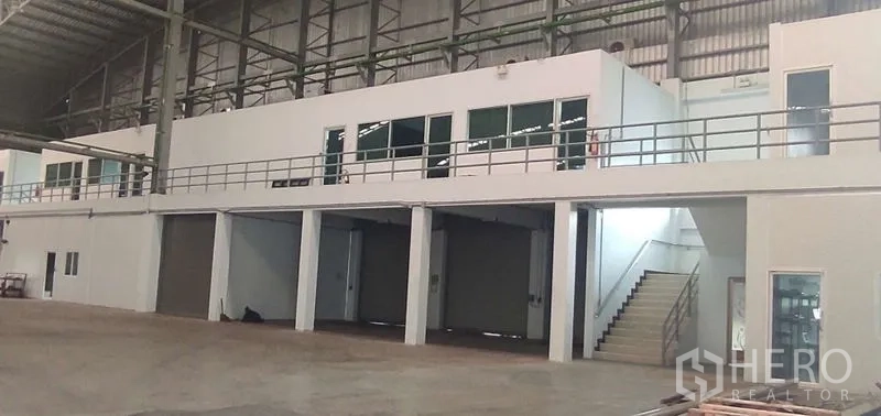 货栈 出租在Nong Chok, Bangkok - 仓库内带玻璃窗的夹层办公室，上方俯视多道卷闸装卸口。