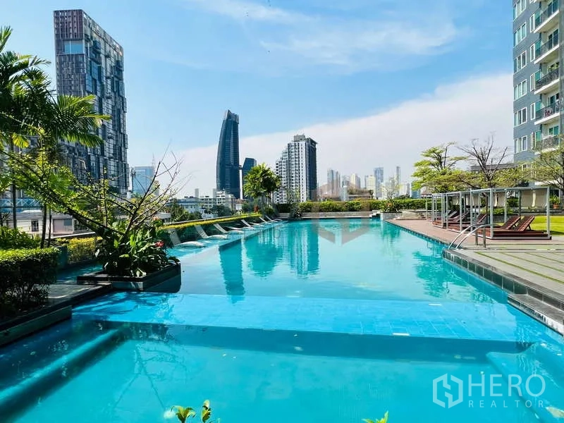 คอนโด ขายในKhlong Toei, Bangkok - สระว่ายน้ำดาดฟ้าพร้อมวิวสกายไลน์และเตียงอาบแดด