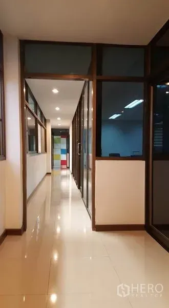 Warehouse for rent or sale - Clean corridor with glass-partitioned offices and polished tile floor.