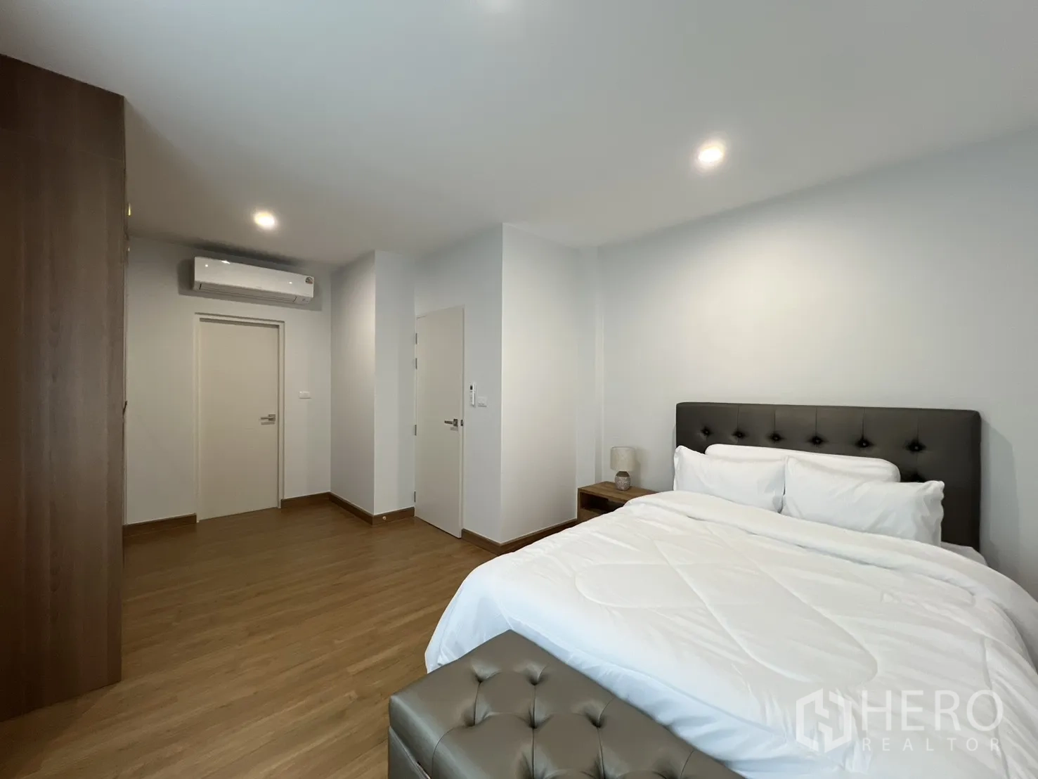 独立式住宅 出租在Prawet, Bangkok - 宽敞卧室，床、长凳与柔色窗帘。