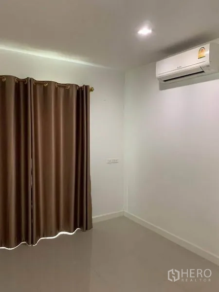 Detached House for sale in Suan Luang, Bangkok - Empty bedroom with air conditioner, recessed lighting and brown blackout curtains.