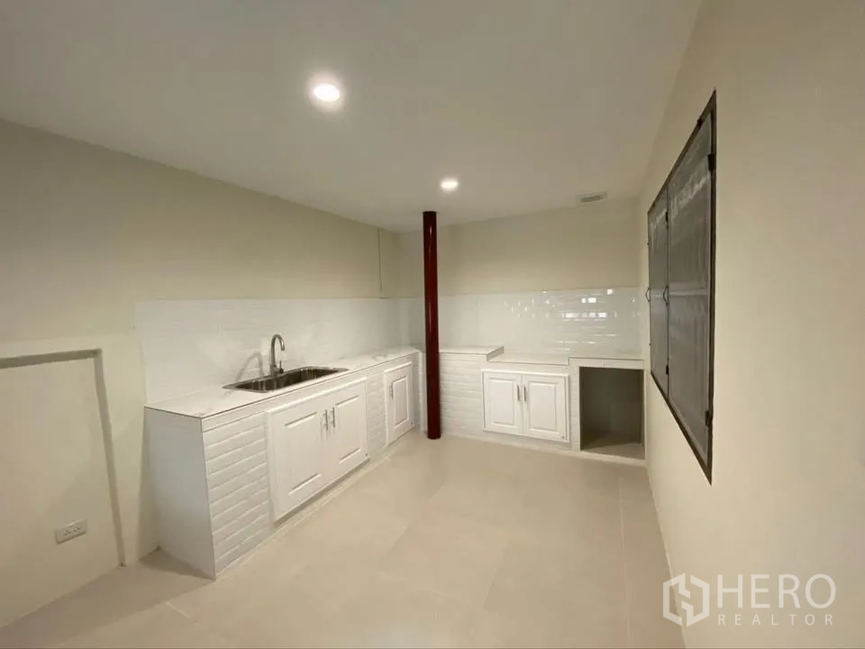 Detached House for rent in Suan Luang, Bangkok - Bright kitchen with white cabinets, sink, and tiled backsplash.