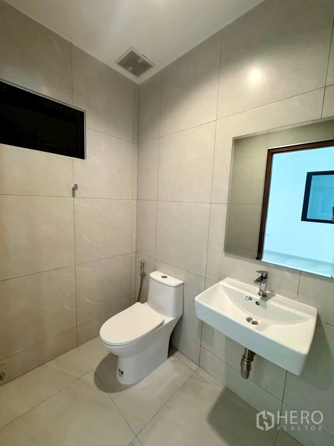 家庭办公室 for rent in Wang Thonglang, Bangkok - 瓷砖浴室，配挂墙式洗手盆、镜子、座厕和小窗。