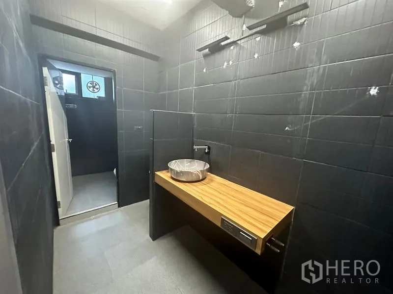 Office Space for rent in Bang Rak, Bangkok - Modern restroom with matte black tiles, wood vanity countertop, and round basin.