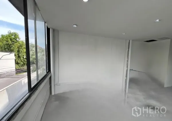 Retail Space for rent in Khlong Toei, Bangkok - Open white-walled retail space with corner windows and recessed ceiling lights.