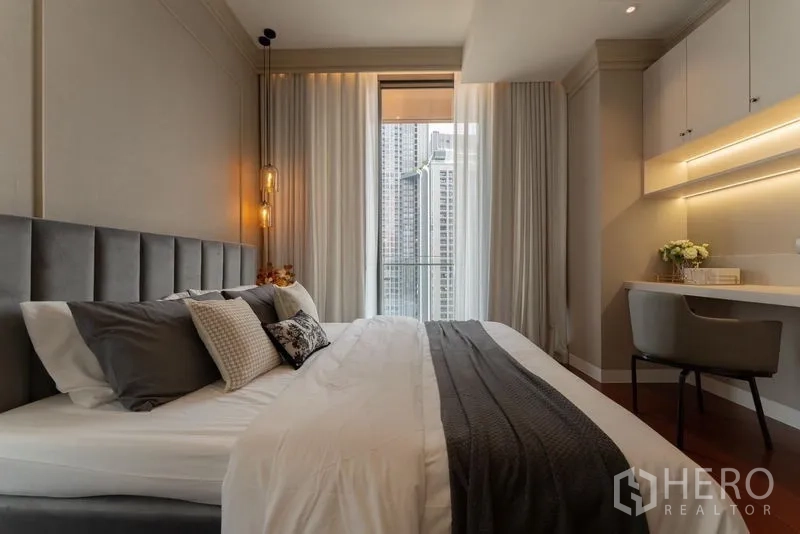 Condominium for rent in Watthana, Bangkok - Bedroom with built‑in study desk, overhead cabinets and access to balcony.