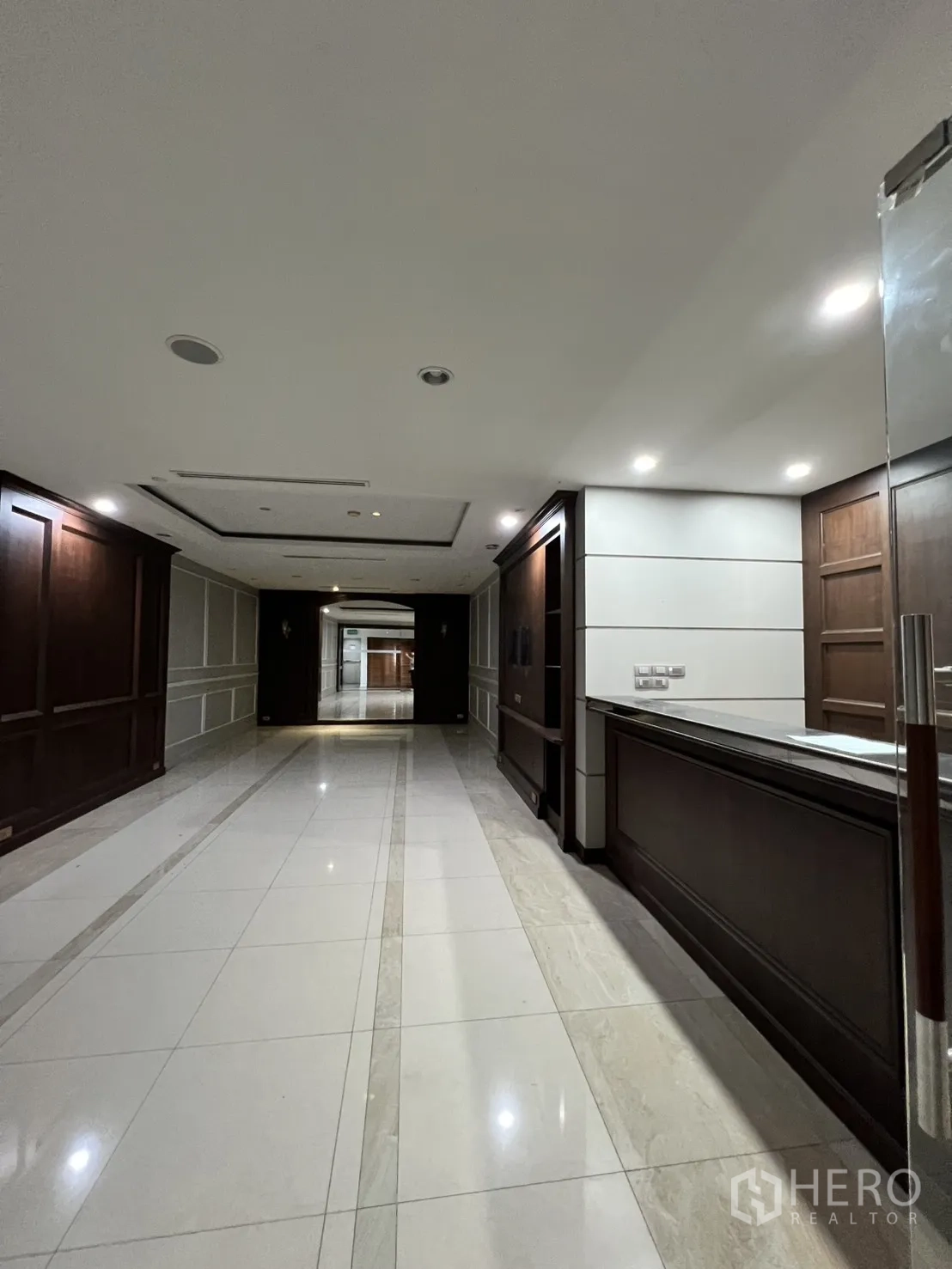 Office Space for rent in Watthana, Bangkok - Corridor with wood paneling and spotlights beside the reception.