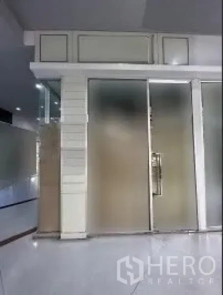 零售空间 出租在Khlong Toei, Bangkok - 室内零售铺位，磨砂玻璃推拉门与铝合金框架，商场走廊内的亮面地砖。