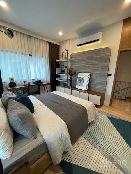 Detached House for sale in Bang Kapi, Bangkok - Secondary bedroom with desk, open shelving, air-conditioning and grey-blue decor.