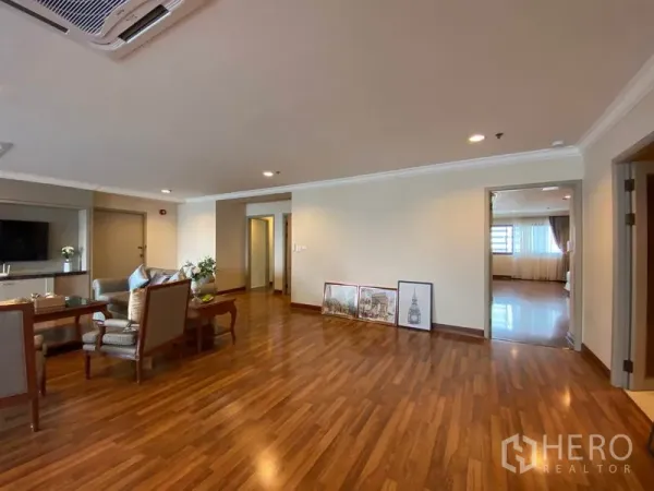 公寓 出租在Watthana, Bangkok - 客厅配休闲沙发，木地板，并有通向卧室的门。