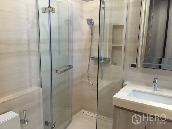 Condominium for rent in Watthana, Bangkok - Contemporary bathroom with glass-enclosed shower, handheld set and sleek vanity.