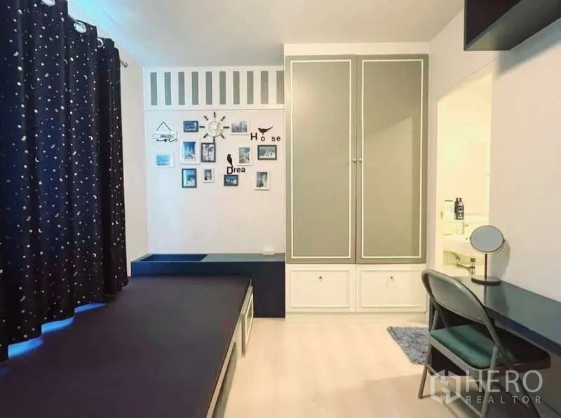 Detached House for rent in Bang Phli, Samut Prakan - Second bedroom angle with wall décor, wardrobe, vanity desk and bathroom entrance.