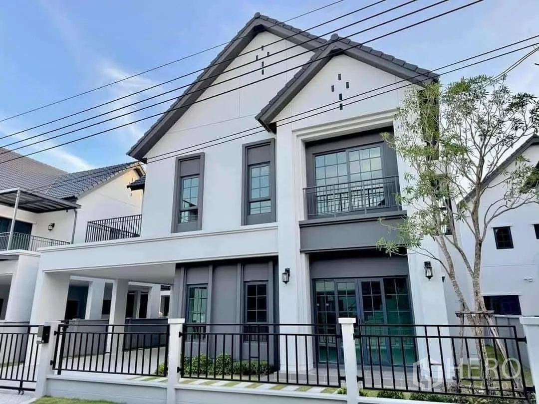 Detached House for rent in Bang Phli, Samut Prakan - Modern two-storey detached house with grey roof, balconies and black metal fence.