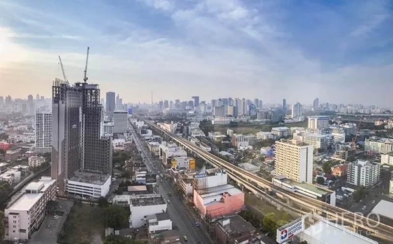 Condominium for rent in Huai Khwang, Bangkok - High-floor city skyline view of Bangkok and an elevated transit line.