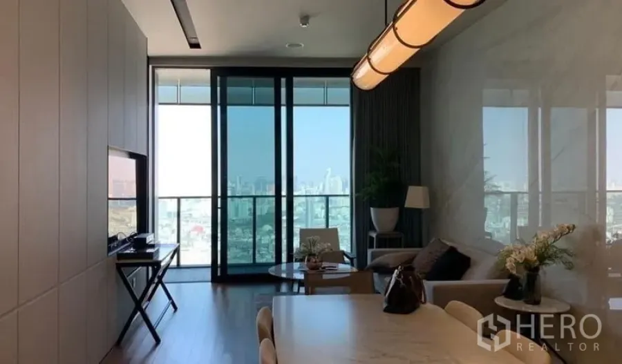公寓 出售在Khlong San, Bangkok - 开放式客餐厅，落地窗与阳台，可观曼谷天际线景色的公寓空间。
