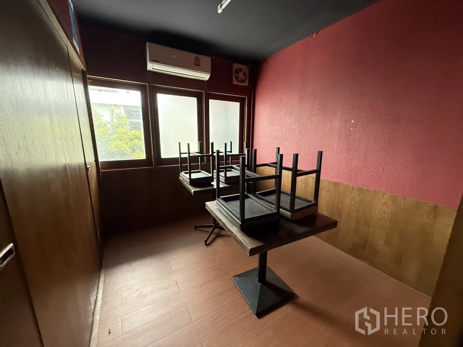 Detached House for rent in Watthana, Bangkok - Private dining room with red wall, frosted windows and stacked tables.