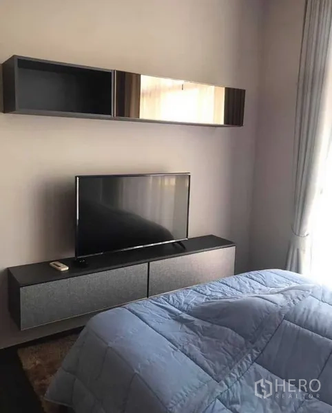 Condominium for rent or sale in Watthana, Bangkok - Cozy bedroom with TV console, wall cabinets and floor-to-ceiling curtains.