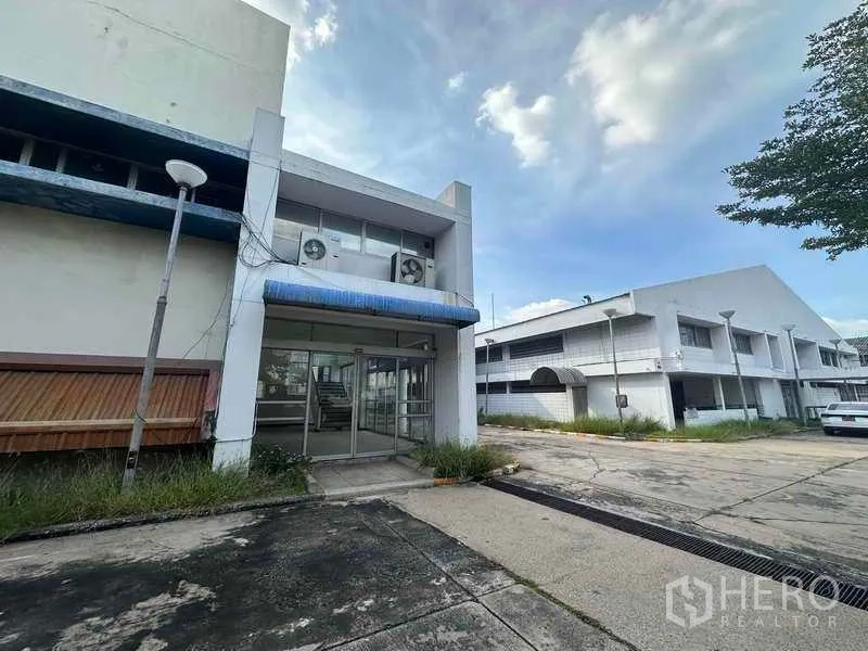 工厂 出租在Khlong Luang, Pathum Thani - 主入口玻璃门与蓝色雨篷，临近厂房